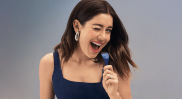 happy brunette model sings using a hair paint brush